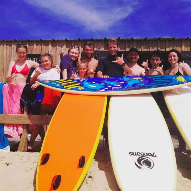 © Photo de groupe du staff avec un cours de surf - Watu Surf