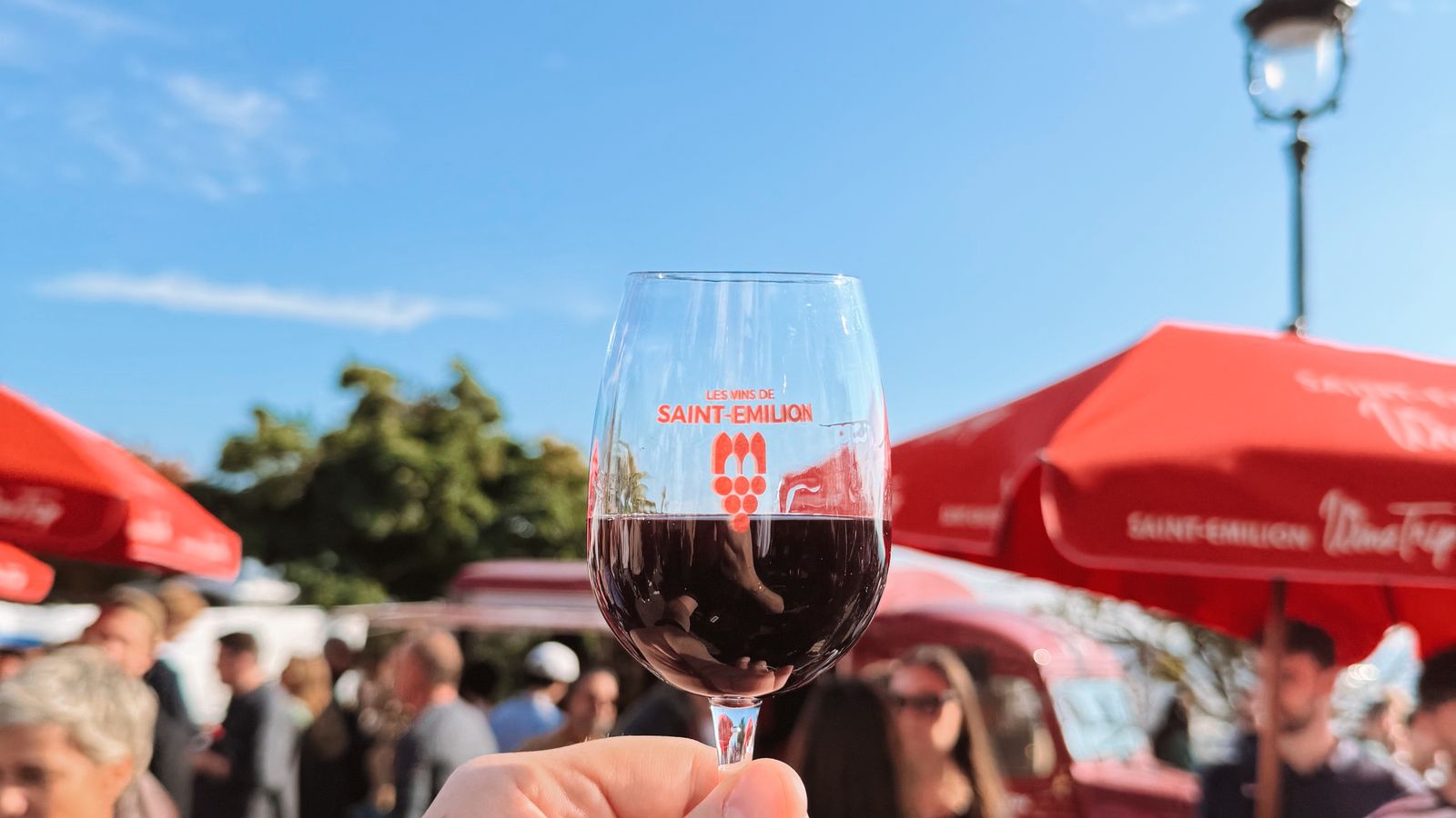 Verre de vin tenu pendant un festival viticole en Gironde