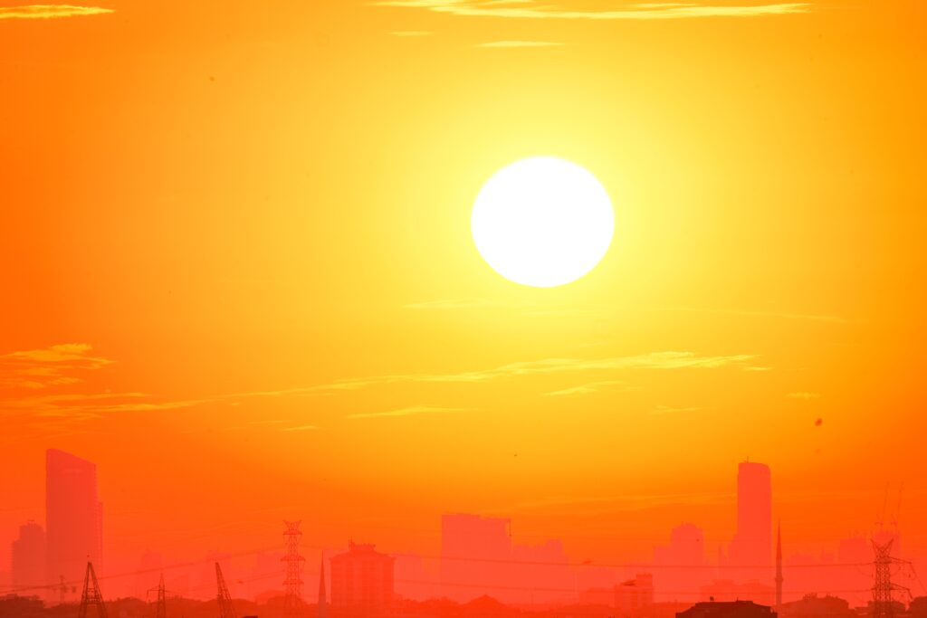 Silhouette d’une ville sous un ciel orange lors d’une forte chaleur
