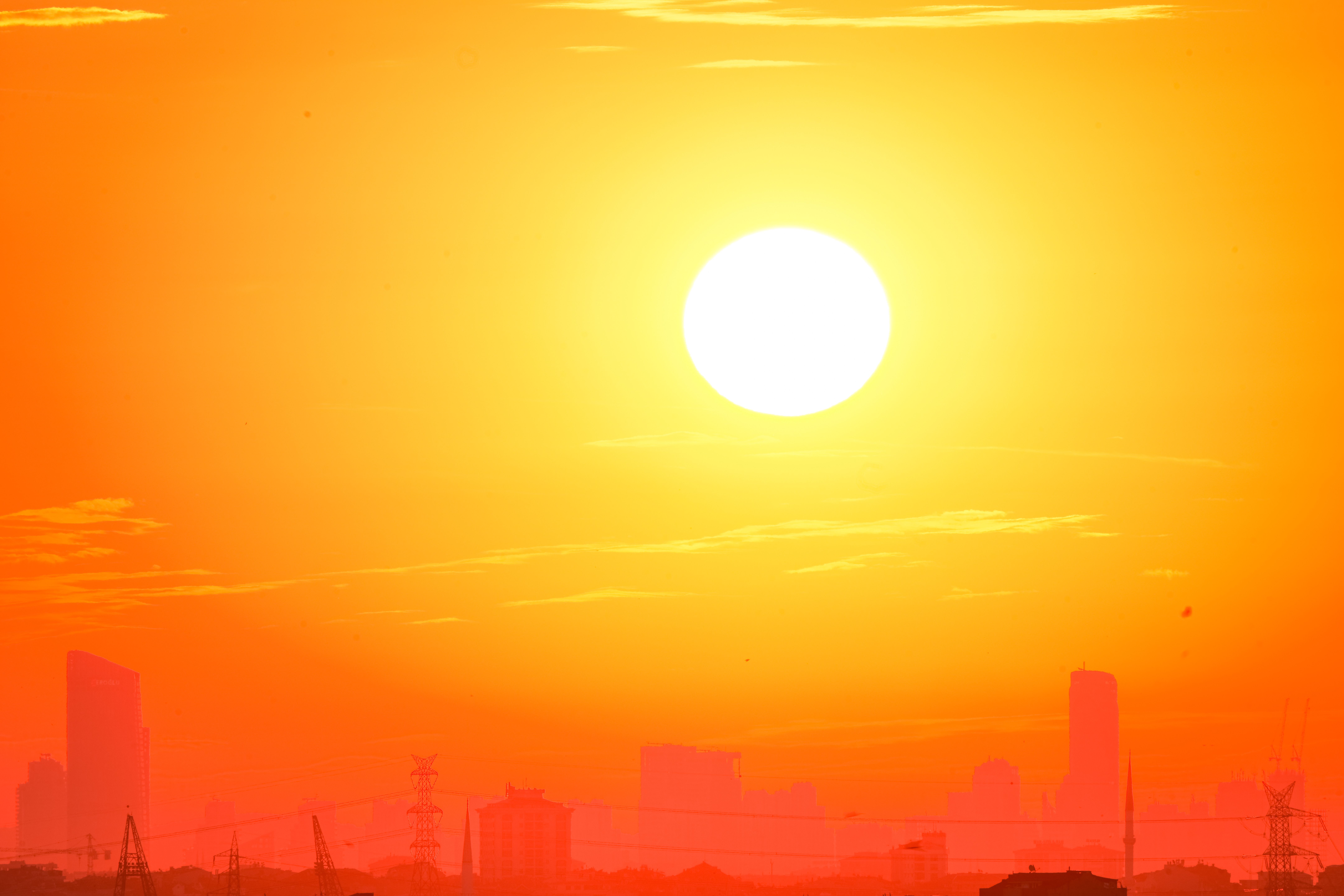 Silhouette d’une ville sous un ciel orange lors d’une forte chaleur