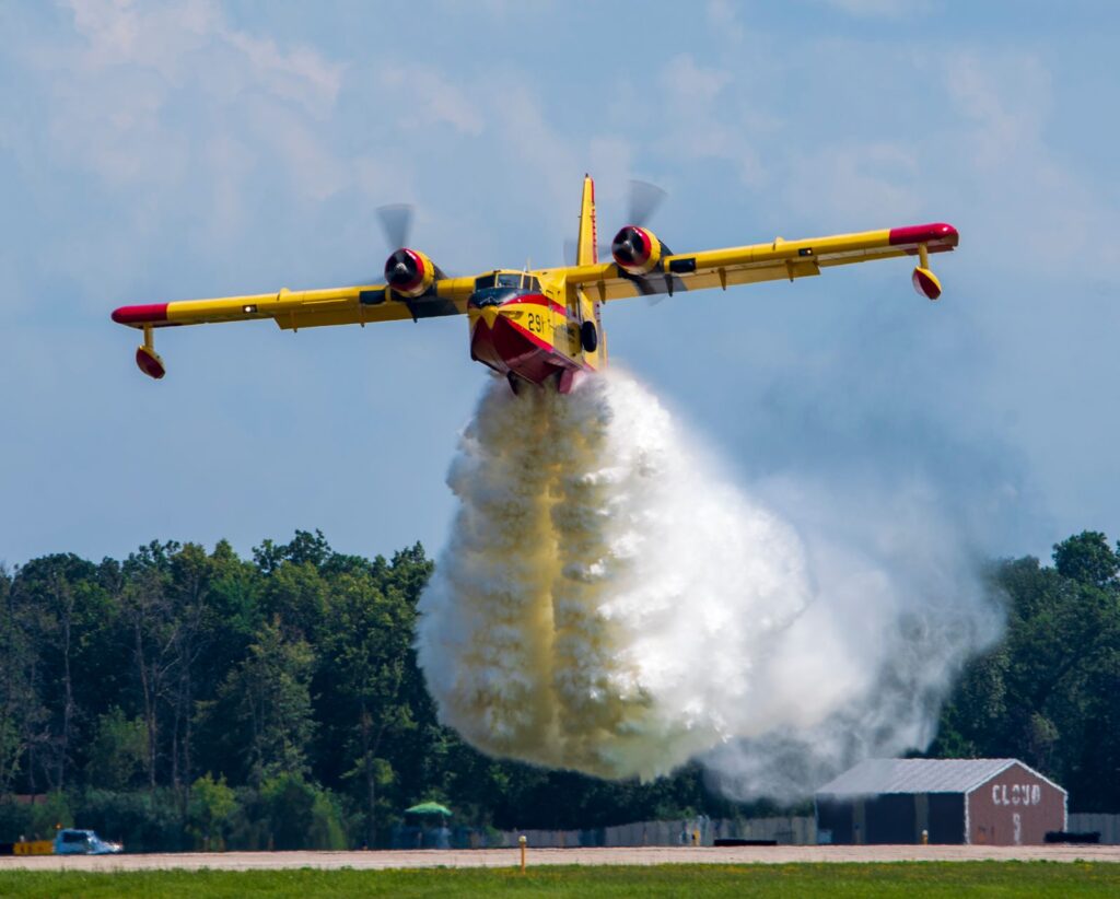 Un avion bombardier d’eau effectue un largage au-dessus d’une forêt