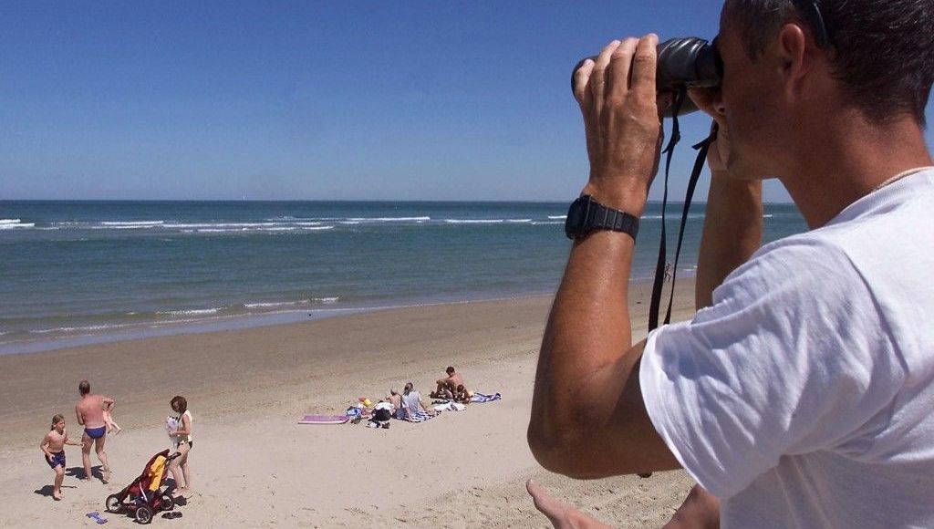 Un maître-nageur surveille des baigneurs sur une plage du littoral girondin