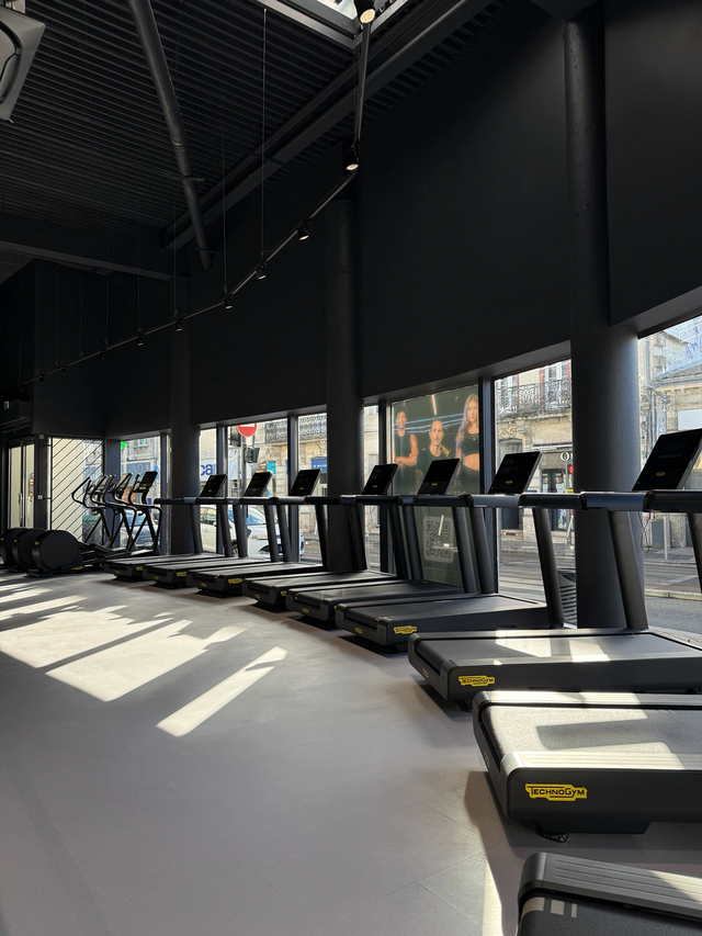 Rangée de tapis de course dans une salle Fitness Park de l'agglomération bordelaise