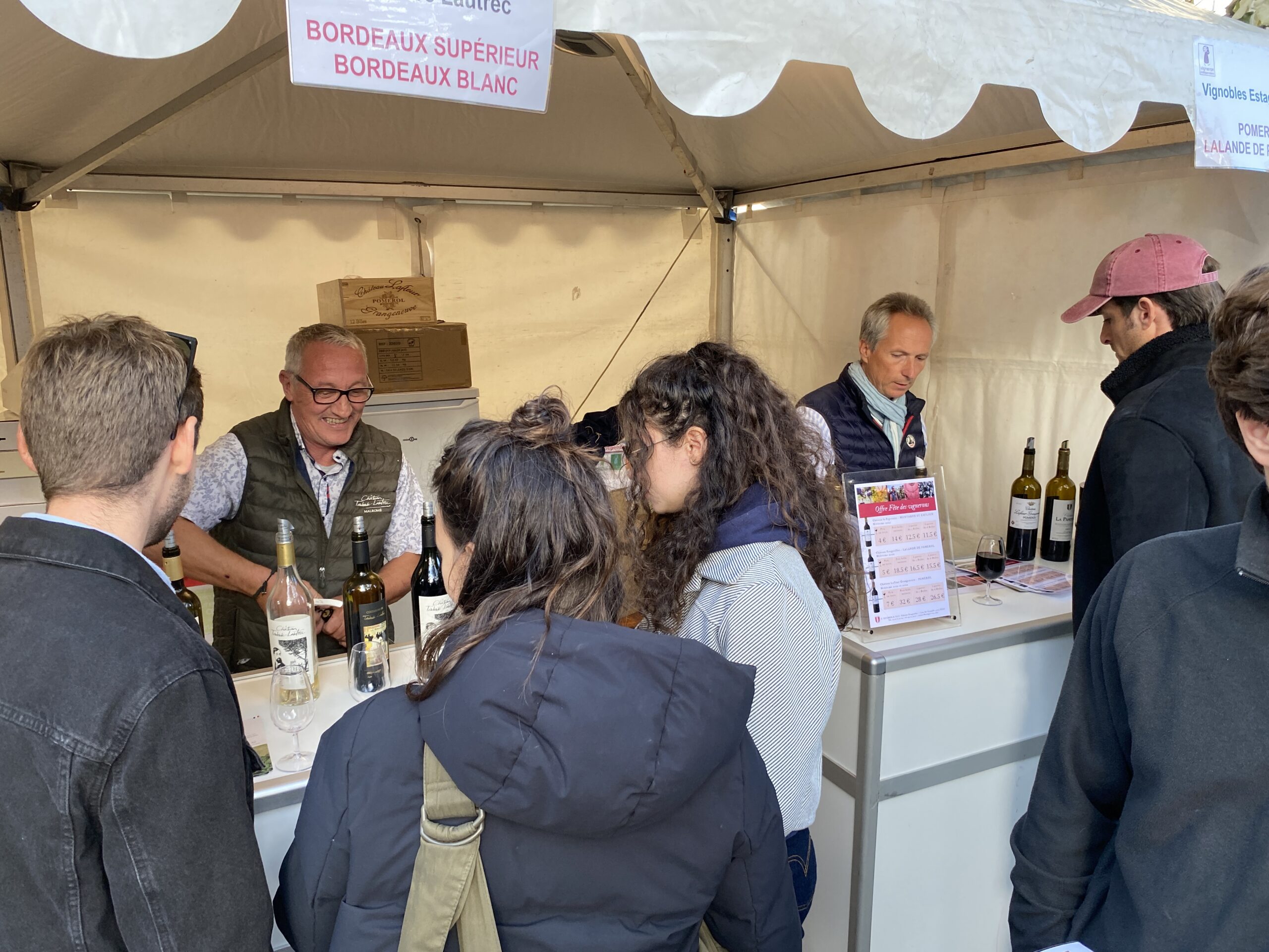 Visiteurs échangeant avec un vigneron indépendant sur son stand