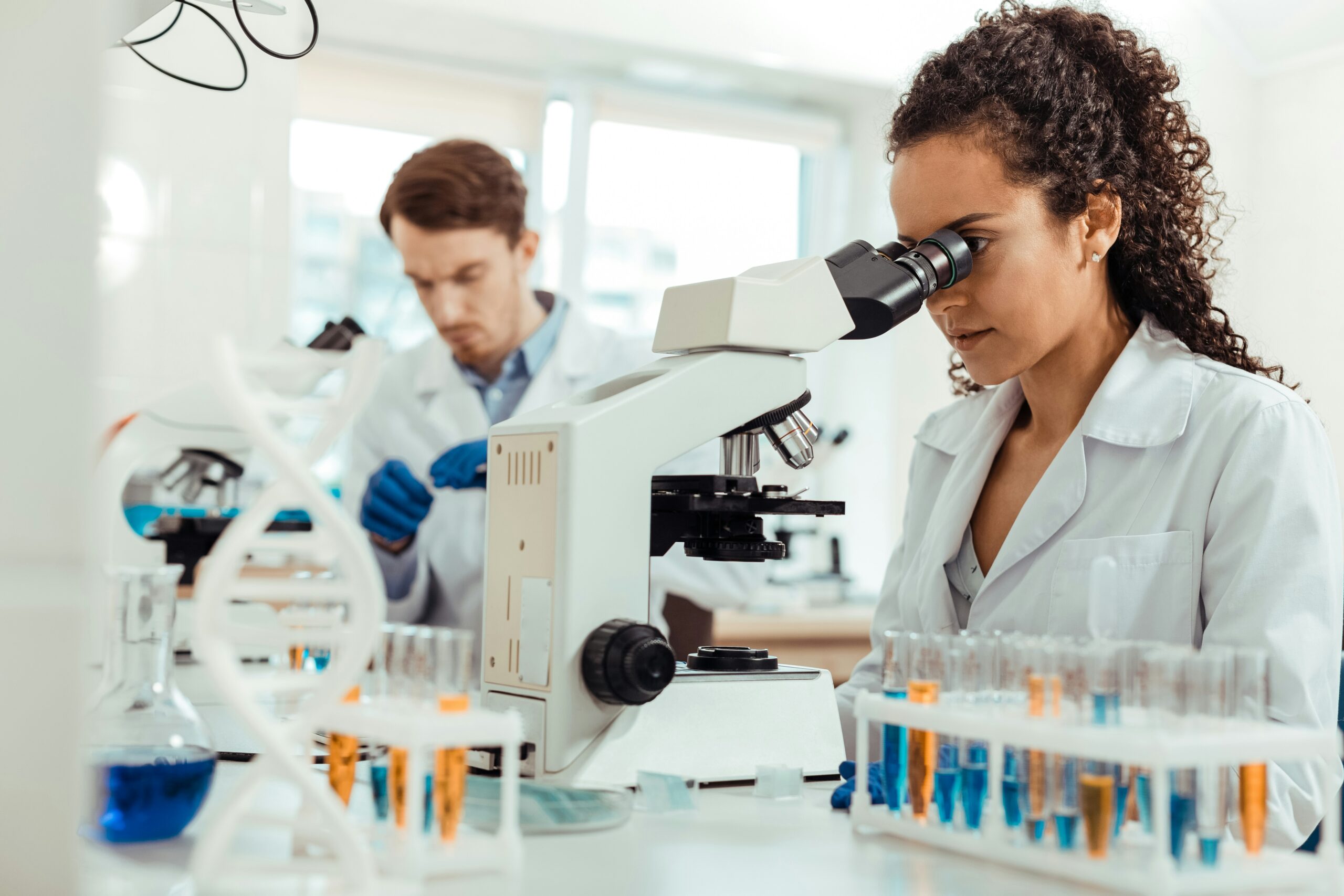 Une professionnelle observe un échantillon au microscope dans un laboratoire
