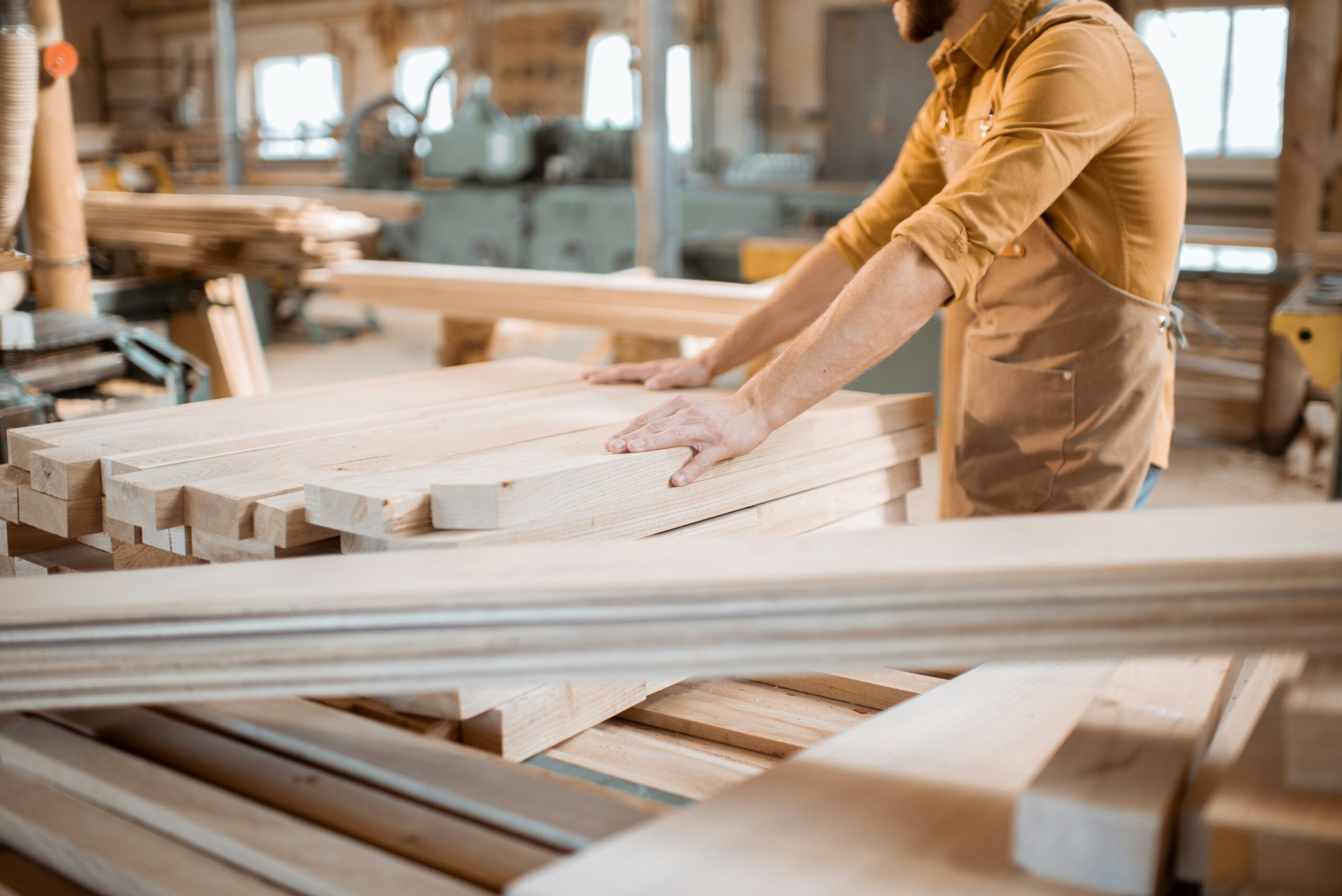 Un artisan travaille des pièces de bois dans un atelier