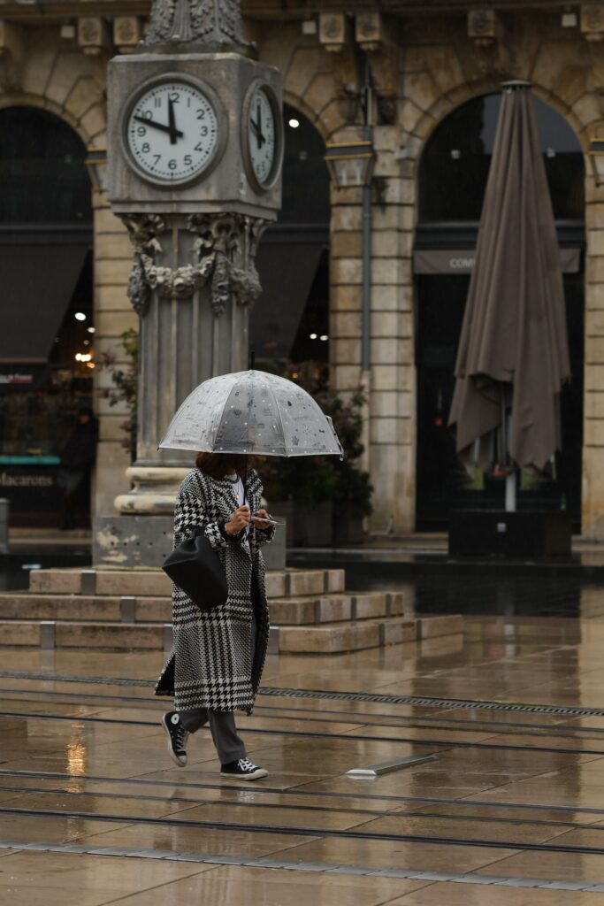 Une personne avec un parapluie marche sous la pluie à Bordeaux