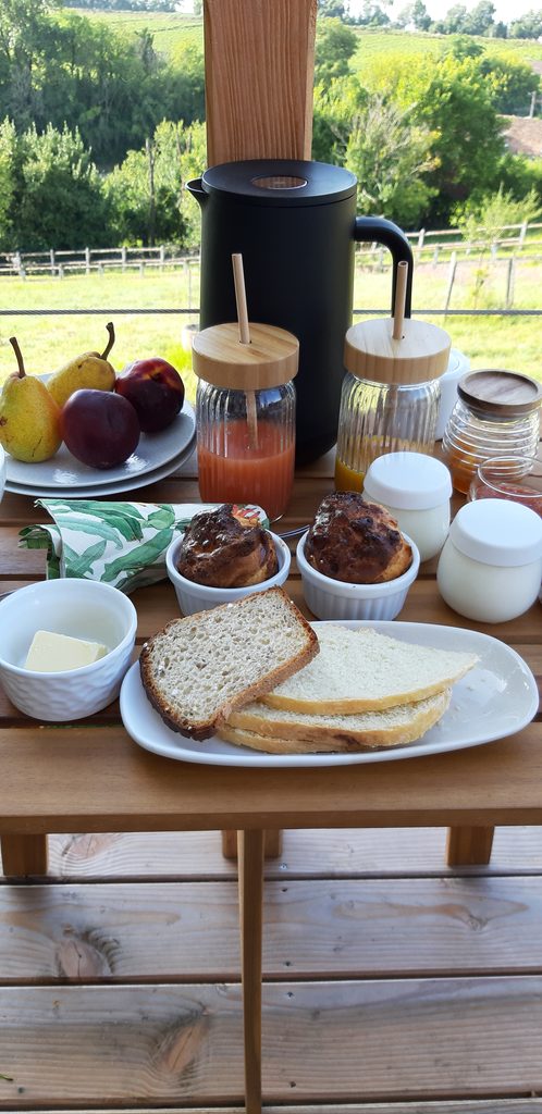 Petit déjeuner servi sur une table en bois devant le paysage